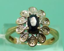 A 9ct gold ring set with an oval sapphire surrounded by diamonds (size O)