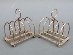 A pair of Edward VII hallmarked silver four-slice toast racks, Sheffield 1904 and 1905,