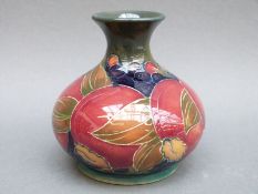 An early Moorcroft vase in Pomegranate pattern on a green ground, signed and dated 1913 to base,
