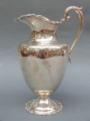 A Mexican silver ewer with scrolling handle,