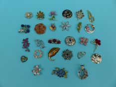 A collection of floral brooches some gem set,