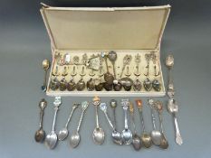 A collection of white metal and plated collectors' spoons,