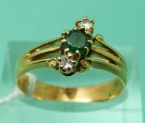 An 18ct gold ring set with a round cut emerald and two diamonds (size P), weight 3.