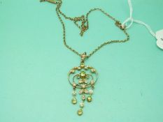 A 9ct gold Edwardian pendant set with seed pearls and peridot on a 9ct gold chain