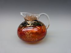 Eisch glass jug with amber and turquoise staining and gold trailed decoration, 19cm in diameter.