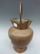 An unusual 19thC pedestal copper twin lipped pitcher with riveted loop handle