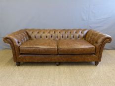 A brown leather Chesterfield sofa (H70 x L216 x D95cm)