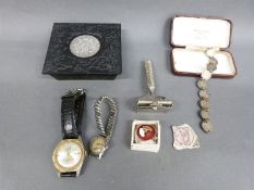 A Maria Theresa coin set into the lid of an embossed metal box,