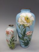 Two Japanese cloisonne vases each decorated with flowers on a pale blue ground,
