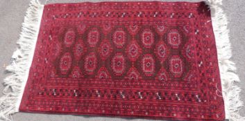 Three Persian rugs, all with geometric motif on red ground,