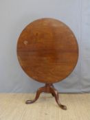 An 18thC mahogany circular tilt top table the turned baluster support on splayed pad feet,