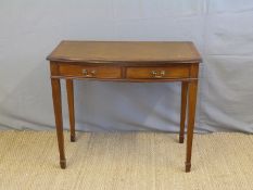A mahogany leather inset bow fronted writing desk with two drawers raised on tapering legs (H76 x