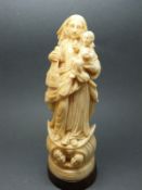 An 18th/19thC carved ivory figure of the Madonna and child with putti below, probably Dieppe,
