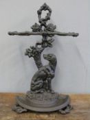 A Coalbrookdale style cast iron umbrella stand with a dog decoration and semicircular drip tray