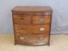 A 19thC mahogany two over two bow fronted chest of drawers with brushing slide to top and oval