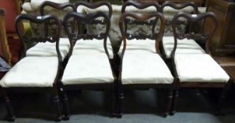 A set of eight upholstered rosewood balloon back dining chairs raised on shaped and turned front