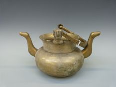 A bronze or brass twin handled pouring kettle probably Benin,