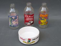 A large collection of vintage milk bottles with advertisements to sides
