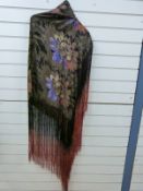 An Art Deco lamé fringed evening shawl woven with daisies on a black ground,