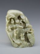 A Chinese carved bowenite jade boulder decorated with figures and animals in a naturalistic setting,