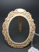 A late 19thC Chinese ivory photo frame with carved decoration of a dragon,