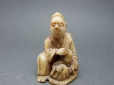 A Japanese Meiji period ivory netsuke of a man with child, 3.