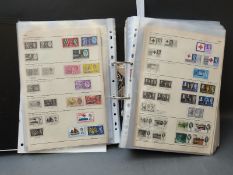 An album of GB stamps in a ring binder George V - Queen Elizabeth II,