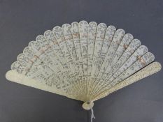 A 19thC Cantonese carved and pierced ivory brise fan decorated with buildings figures in a