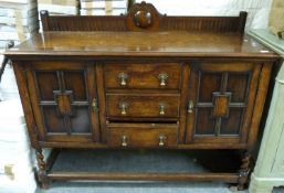 A panelled oak sideboard with three drawers (H98 x W138 x D56)