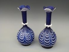 A pair of blue glass vases with applied decoration.