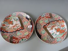 A pair of Japanese Imari chargers each decorated with birds and flowers and highlighted in gilt,