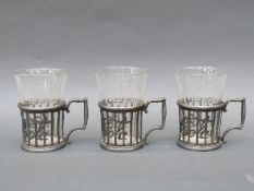 Three Coca-Cola glasses and holders circa 1900 with filling line near bottom of glass