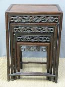 A Chinese nest of four graduated padauk tables with carved freize surrounds and shaped legs and