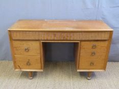 A retro Heal's satinwood dressing table with an arrangement of eight variously graduated drawers