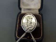 A silver ring with an engraved dragon chasing a flaming pearl on a newer setting