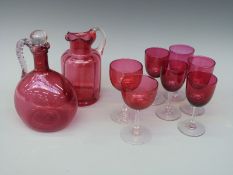 A small collection of cranberry glass including jug and decanter