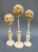 Three ivory puzzle balls on stands