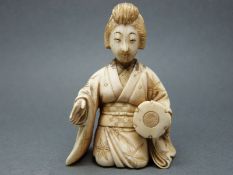 A Japanese Meiji period ivory okimono of a lady playing a drum, 5.
