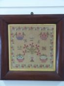 A framed Victorian sampler with floral motif to centre, initialled 'HS' to centre,