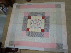 An early 19thC patchwork quilt with hexagonal pattern to centre and with horse and rider and floral