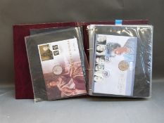 An album of GB coin/stamp covers,