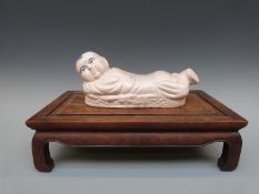 A 19thC Chinese hardwood stand and a Chinese pottery figure (stand H11 x L40 x D24cm,