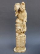 A Japanese Meiji period okimono of two figures atop a boulder,