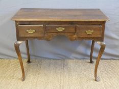 A 19thC oak lowboy with three drawers raised on cabriole legs (H74 x W101 x D59cm)
