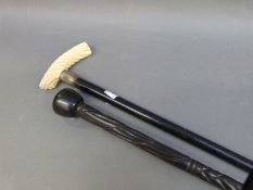 A wlaking stick with twist carved ivory handle and an African example
