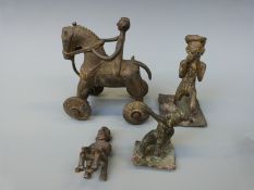 Four Ashanti brass figures including a wheeled horse and rider, a figure playing an instrument,