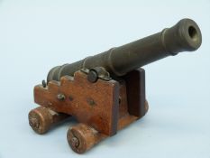 A bronze table cannon with 6.5 inch multi stage barrel on a wooden wheeled carriage.