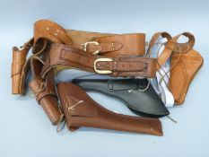 Five leather revolver holsters, two on matching belts, some with embossed decoration.
