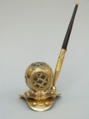 A pen holder in the form of a diver's helmet