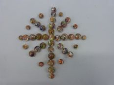 Forty three glass marbles, all with multicoloured twists,